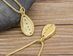 Detailed view of gold plated shell pendant necklace with colorful cubic zirconia stones.
