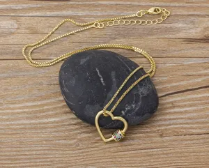 Collier cœur mousqueton plaqué or avec des pierres zircone multicolores sur fond bois détail