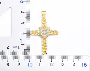 Gold cross pendant detail view showing sparkly cubic zirconia paved heart and chain link texture.