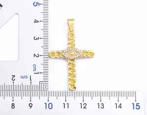 Close-up detail view of gold plated cross pendant featuring sparkling cubic zirconia details.