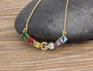Detailed view of gold-plated letter G necklace with colorful cubic zirconia stones.