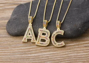 Close-up detail of colorful paved cubic zirconia letter pendants, sparkling iced out style.