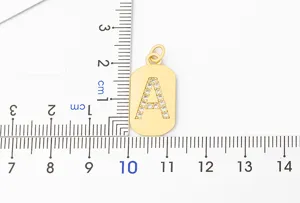 Gold plated letter A pendant detail with cubic zirconia stones and size measurement ruler.
