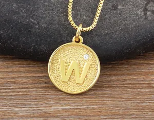 Close-up detail of gold plated letter W pendant necklace with sparkling zirconia gem.