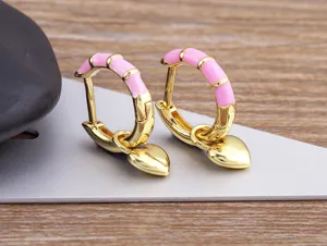 Gold-plated hoop earrings with pink enamel bamboo segments and cute heart charms for women.