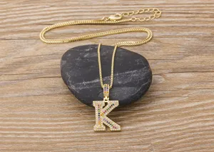 Detailed shot of a gold-plated letter K pendant necklace paved with colorful cubic zirconia.