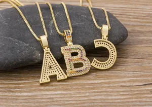 Detail shot of gold letter pendant necklaces A B C with colorful pavé cubic zirconia stones.