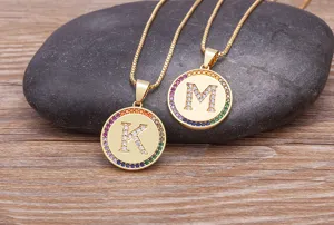 Gold 26 letter pendant necklace with rainbow cubic zirconia pave circular design detail.
