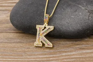 Close-up detail of the iced out letter K pendant necklace with colorful micro paved zirconial.