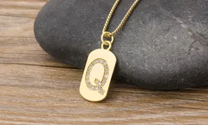 Gold letter Q pendant necklace detailed view, cubic zirconia crystal gemstone, elegant jewelry.