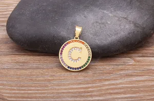 Detailed view of gold round letter C pendant necklace with colorful micro paved cubic zirconia.