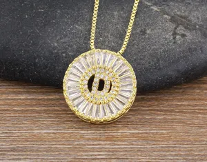 Primo piano dettagliato di una collana con ciondolo rotondo dorato e lettera D con zirconi.