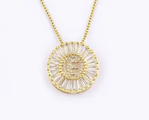 Primo piano di una collana con ciondolo a lettera E circolare placcata in oro con zirconi luminosi.