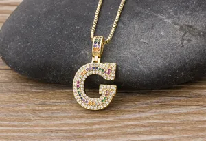 Detailed close-up of the golden letter G pendant inlaid with sparkling multi-colored cubic zirconia.
