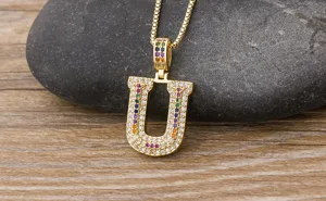 Detailed shot of a stylish gold-plated letter U pendant necklace with colorful cubic zirconia.