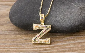 Close-up detail shot of a gold-colored letter Z pendant necklace paved with colorful stones.