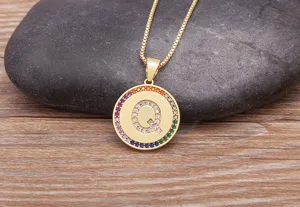 Gold initial Q pendant necklace featuring colorful cubic zirconia pave stones on dainty chain.