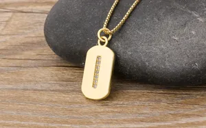Detailed close-up of a minimalist 18K gold plated letter pendant necklace with sparkling zircons.