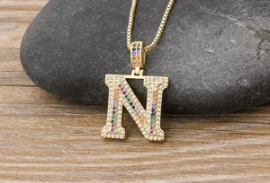 Close-up detail shot of a gold-plated letter N pendant necklace with colorful cubic zirconia.