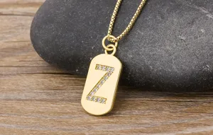 Gold Z letter pendant necklace detail shot, showcasing sparkling paved zircon on a shiny gold tag.