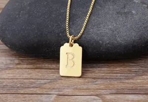 Collana con ciondolo lettera iniziale oro, dettaglio catena fine, stile gioiello di moda.