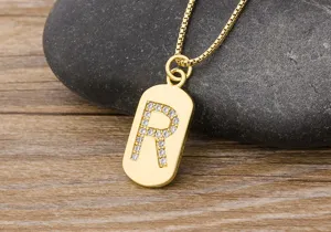 Gold letter R pendant necklace with sparkling zirconia stones, delicate chain detail view.