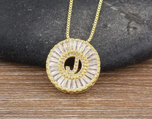 Primo piano dettagliato di una collana con ciondolo iniziale J dorata con zirconi.