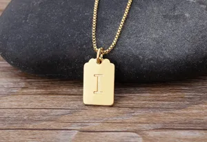 Elegante collana con pendente quadrato e iniziale dorata minimalista, accessorio chic.