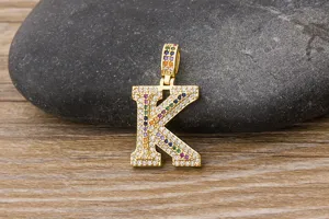 Closeup view of a gold-plated hip-hop letter K pendant paved with colorful cubic zirconia.