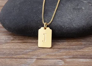 Primo piano dettagliato di una collana minimalista placcata oro con ciondolo lettera J.