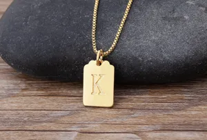 Collana minimalista placcata in oro con piccolo ciondolo quadrato lettera K, gioiello elegante.