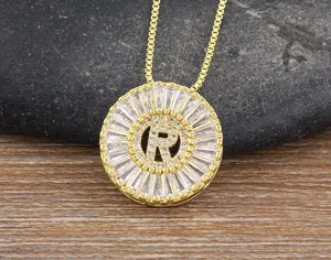 Primo piano dettagliato della collana con ciondolo lettera R placcato oro con zirconi.