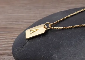 Primo piano dettagliato di una delicata collana con ciondolo quadrato placcato oro lettera A.