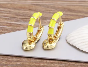 Gold plated hoop earrings featuring bright yellow enamel bamboo details and dangling hearts.