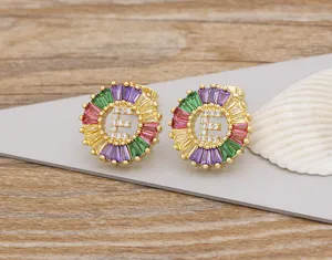 Detail shot of letter E stud earrings featuring colorful crystal halo and paved cubic zirconia.