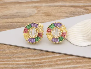 Close-up detail view of colorful baguette cubic zirconia letter U stud earrings on gray card.