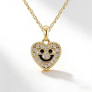 Collana con ciondolo a cuore smiley dorato primo piano, dettagli in zirconi, catena chic.