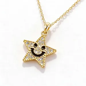 Dettaglio della collana con ciondolo a stella dorata, cristalli pavé e viso sorridente.