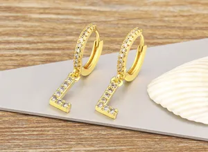 Detail shot of elegant gold plated letter L micro paved zircon hoop earrings close up.