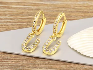 Detailed view of 18k gold plated U letter hoop earrings with sparkling cubic zirconia.