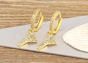 Detail view of gold letter Y hoop earrings with micro-set cubic zirconia, delicate jewelry.