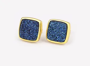 Close-up detail of vintage square earrings featuring dark blue druzy stone and gold metal rim.