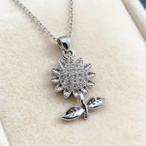 Detailed close-up of a silver-toned rhinestone sunflower pendant necklace with chain