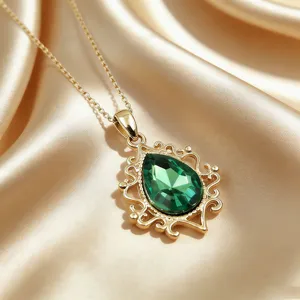 Dettaglio di una collana vintage con ciondolo a goccia verde in montatura dorata fine.