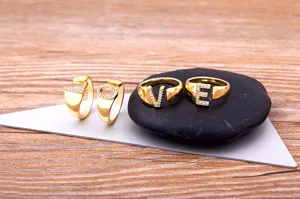 Detail shot of gold-plated letter rings paved with sparkling zircon stones on display.