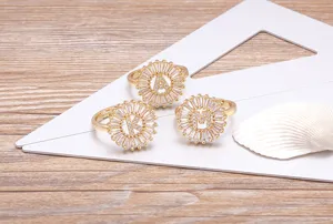 Close-up of gold-plated circular zircon alphabet rings displayed nicely on a white card.