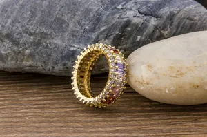 Vista detallada del anillo de eternidad de circonita baguette multicolor, joyería dorada.