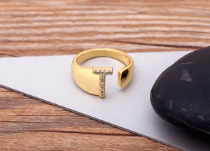 Close-up detail of 18k gold plated open letter T ring sparkling with cubic zirconia.