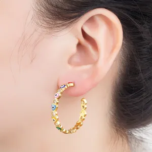 Gold plated evil eye heart hoop earrings detail shot showing colorful enamel and sparkling stones.