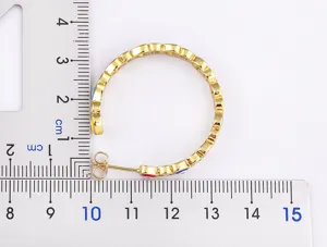 Detailed view of 18k gold plated evil eye heart star hoop earrings, size reference.